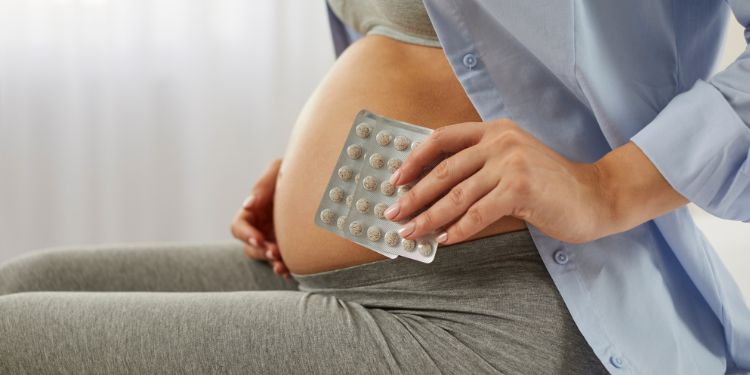 pregnant woman taking prenatal vitamin